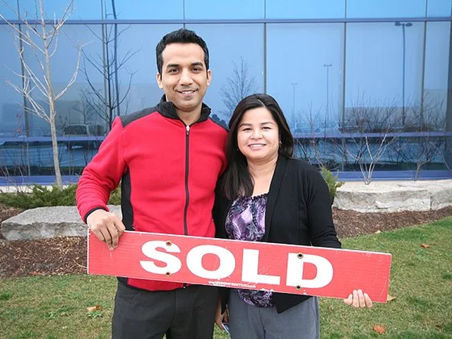 FairCommission repeat client holding a sold sign with Vic Singh